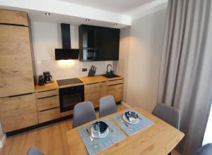 a kitchen with a table and chairs in a room at Może Morze - Rezydencja Ustronie Morskie in Ustronie Morskie