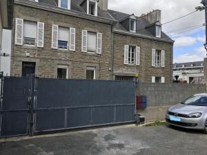 ein Auto, das auf einem Parkplatz neben einem Zaun geparkt ist in der Unterkunft Grand et Charmant 3 pièces Breton Saint Brieuc Centre in Saint-Brieuc