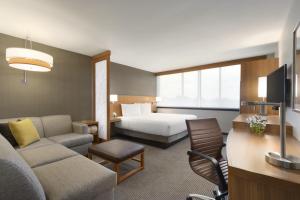 a living room filled with furniture and a large window at Hyatt Place Chicago O'Hare Airport in Rosemont