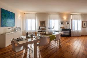 uma sala de estar com mesa e cadeiras e uma cozinha em Oasi Picolit em Povoletto
