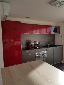 uma cozinha com armários vermelhos e uma bancada em Studio de Lokentaz em Saint-Gildas-de-Rhuys