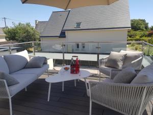 un patio con 2 sofás y una mesa con bebidas. en Studio de Lokentaz en Saint-Gildas-de-Rhuys