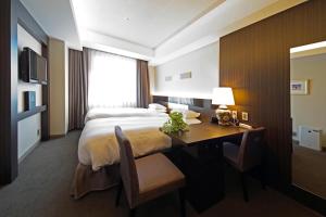 a hotel room with a bed and a desk with a desk at Hotel Riverge Akebono in Fukui