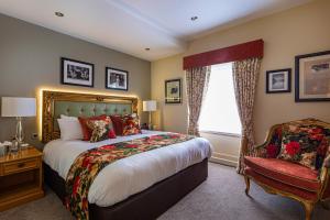 a bedroom with a large bed and a large window at The Rutland Arms Hotel, Bakewell, Derbyshire in Bakewell