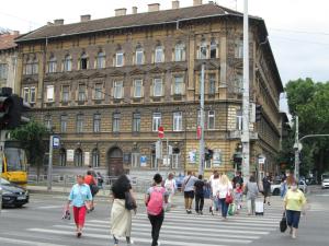 un grupo de personas cruzando una calle frente a un edificio en Lavender Apartment, en Budapest