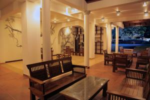 a lobby with benches and tables in a building at Wunderbar Beach Hotel in Bentota