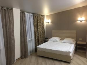 1 dormitorio con cama blanca y ventana en Pegas Club Hotel, en Tula