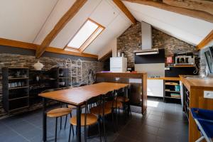 a kitchen with a wooden table and stools at Rustig gelegen gîte nabij Houffalize in Houffalize