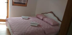 a pink bed with pink pillows on top of it at Holiday Home Adna in Bihać +55 photos