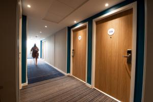 拉特斯特德布赫Holiday Inn Express - Arcachon - La Teste by IHG的走下办公楼走廊的女人