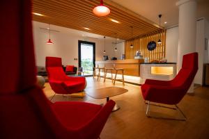 拉特斯特德布赫Holiday Inn Express - Arcachon - La Teste by IHG的带红色椅子和桌子的客厅 更多35张照片