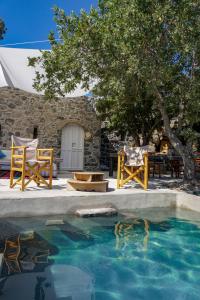 een zwembad met stoelen en een tafel en een boom bij My Old Stone House in a 2 000 sqm private garden with Fab Glamping Tent in Mandrákion