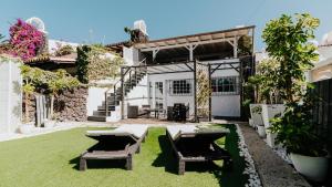 eine Terrasse mit 2 Stühlen und einem Tisch im Hof in der Unterkunft Casa La Fula Negra in Los Realejos