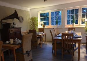 - une salle à manger avec des tables, des chaises et des fenêtres dans l'établissement Hotel KAUP, à Paderborn