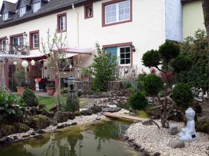 a garden with a pond in front of a house at Ferienhaus Blue in Berlingen