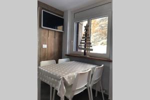 a dining room with a table and a christmas tree on the window at Piccolo paradiso in centro Cervinia in Breuil-Cervinia
