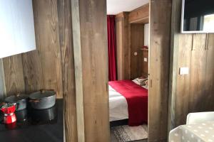 a small bedroom with a bed and a red blanket at Piccolo paradiso in centro Cervinia in Breuil-Cervinia