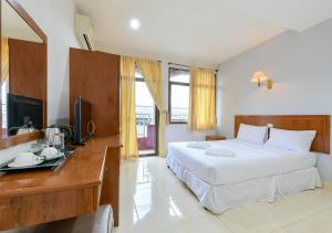 a bedroom with a bed and a desk and a television at Sun & Beach in Pattaya South