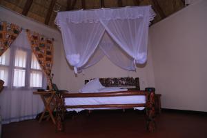 a bedroom with a bed with a canopy at Acaki Lodge in Kitgum