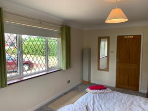 a bedroom with a bed and a window at Eastfield B & B in Ringwood