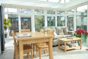 una sala da pranzo con un tavolo e un divano di Weston Cottage a Poole