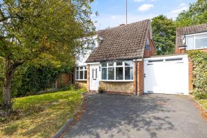 een vrijstaand huis met een witte garage bij The Spinney - Perfect for Contractors, Large Groups & Families in Wolverhampton