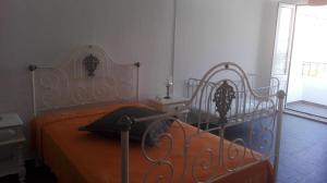 a bedroom with a bed with an orange bedspread at Casa dos Avós in Alcácer do Sal