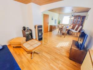 uma sala de estar com pisos em madeira e uma sala de estar com televisão em Ferienwohnung Ella em Todtnau
