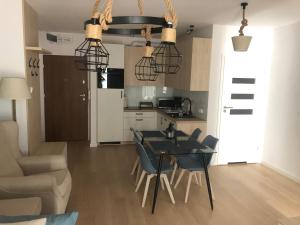 kuchnia i jadalnia ze stołem i krzesłami w obiekcie Nadmorskie Tarasy Apartament 312 w Kołobrzegu