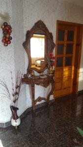 a mirror on a table in a room with a vase at Сара in Gabrovo