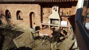a patio with a table and chairs and a brick oven at Сара in Gabrovo