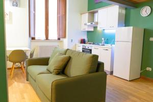 a living room with a couch and a kitchen at Casa il sogno di Beatrice in LʼAquila