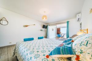 a bedroom with a bed with blue pillows on it at Studio du Lagon vue mer St Gilles les Bains Centre 500m de la plage in Grand Fond