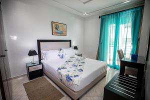 Appart Hotel Rania في طنجة: غرفة نوم بسرير كبير مع ستائر زرقاء