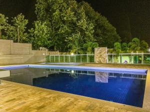 a large swimming pool with blue water at night at APARTMENTFORSTAY 18 Tânger in Marília