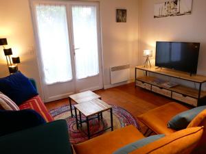 sala de estar con sofá y TV en Netmust vacances, en Saint-Palais-sur-Mer