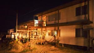 a building with a hammock outside of it at night at El Palafito in La Pedrera