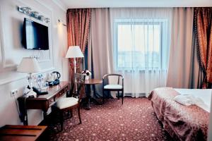 Pokój hotelowy z sypialnią z biurkiem i łóżkiem w obiekcie Ring Premier Hotel w Jarosławiu