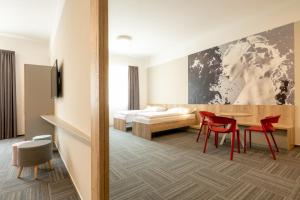 ein Hotelzimmer mit einem Bett, einem Tisch und Stühlen in der Unterkunft SLADOVNA Apartments in Olomouc