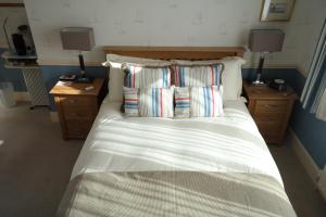 una camera da letto con letto con cuscini e 2 comodini di Weston Cottage a Poole
