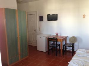 een kamer met een bed en een tafel en een kamer met een bed bij Bay Watch in Karpathos