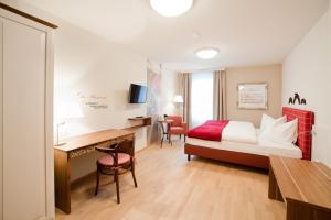 a hotel room with a bed and a desk at Gasthof Restaurant Zum Brauhaus in Hartberg