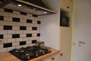 a kitchen with a black and white tiled wall at Maison à Westende in Middelkerke