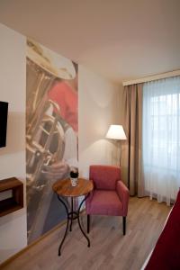 un soggiorno con una sedia rossa e un tavolo di Gasthof Restaurant Zum Brauhaus a Hartberg