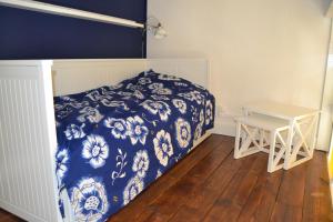 um quarto com uma cama azul e branca e uma mesa em Maison à Westende em Middelkerke