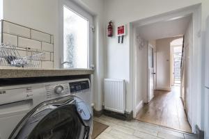 a laundry room with a washing machine in it at Sandy Retreat - 3 Bedroom Holiday Home - Tenby in Tenby