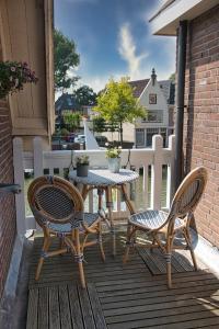 a patio with two chairs and a table on a deck at Com-In in Alkmaar