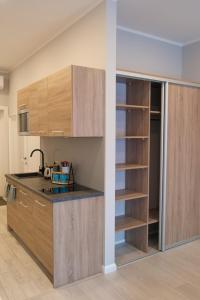 une cuisine avec des placards en bois et une étagère à livres dans l'établissement Kungu Apartments in Riga Old Town, à Riga