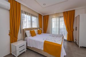a bedroom with a large bed with orange curtains at Salkım- 4 Bedroom Holiday Villa in Oludeniz in Fethiye