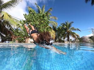a man is swimming in a pool with a surfboard at Hotel Fenix Beach Cartagena in Tierra Bomba
